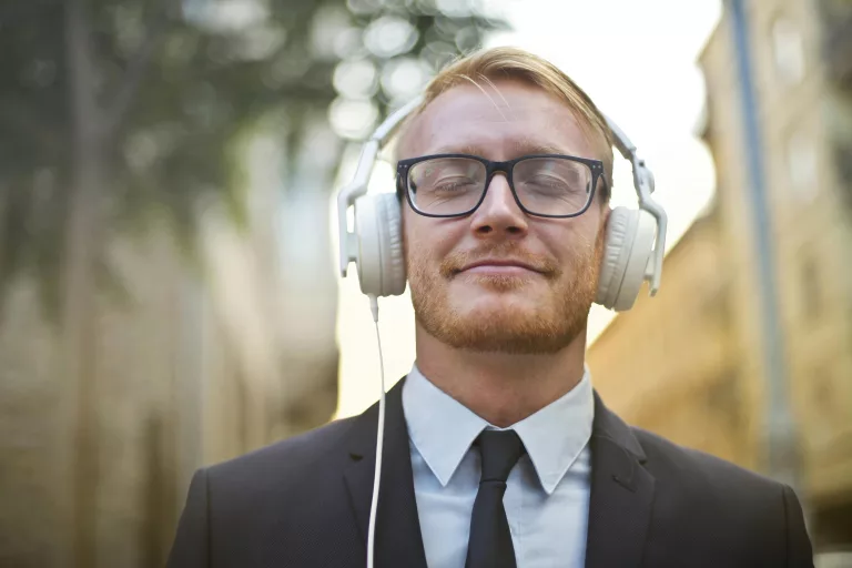 Homme dans la rue écoutant de la musique via son casque